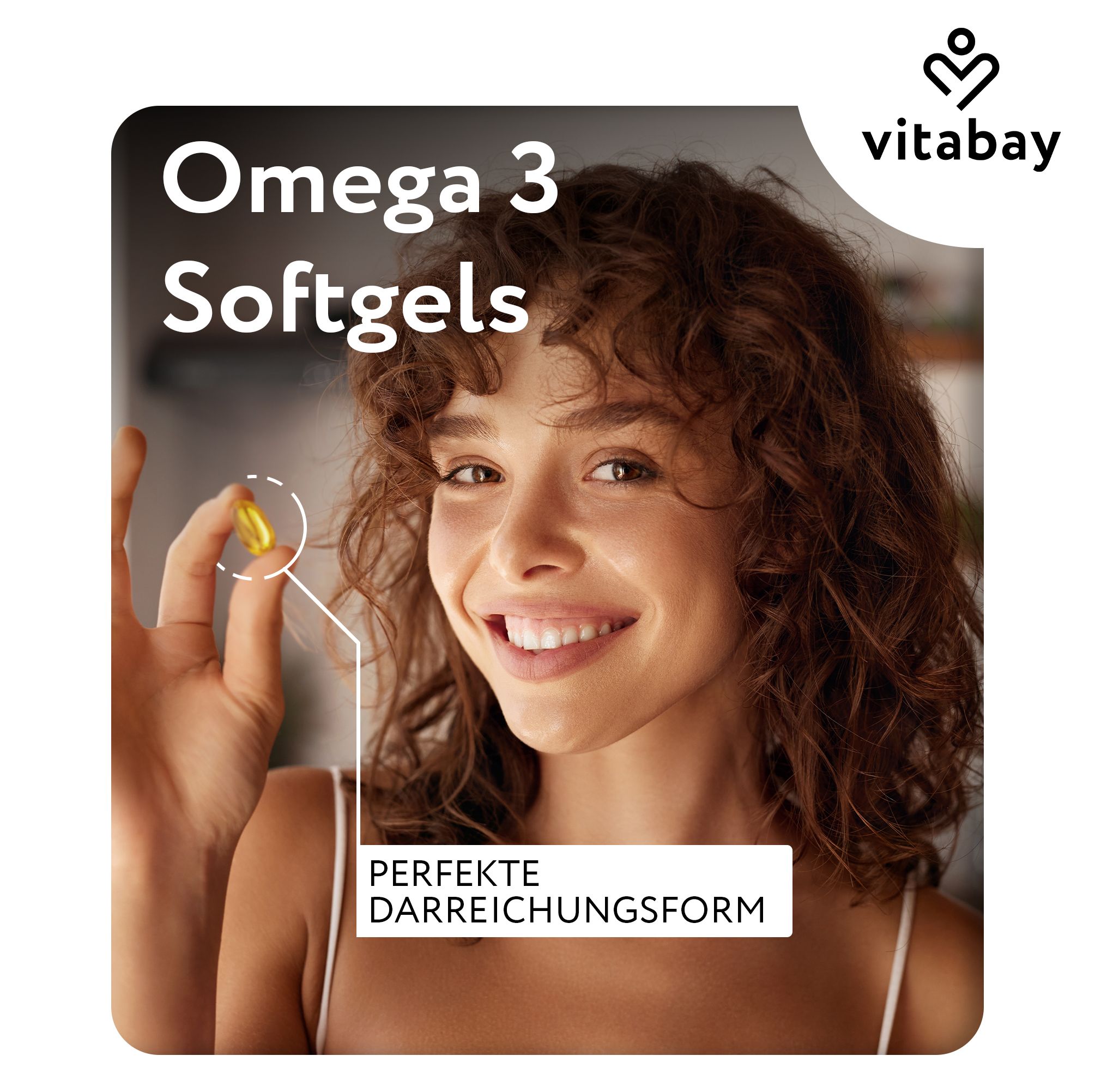 Donna tiene una capsula morbida gialla. Testo: Omega 3 Softgels, Forma di somministrazione perfetta. Marchio Vitabay.