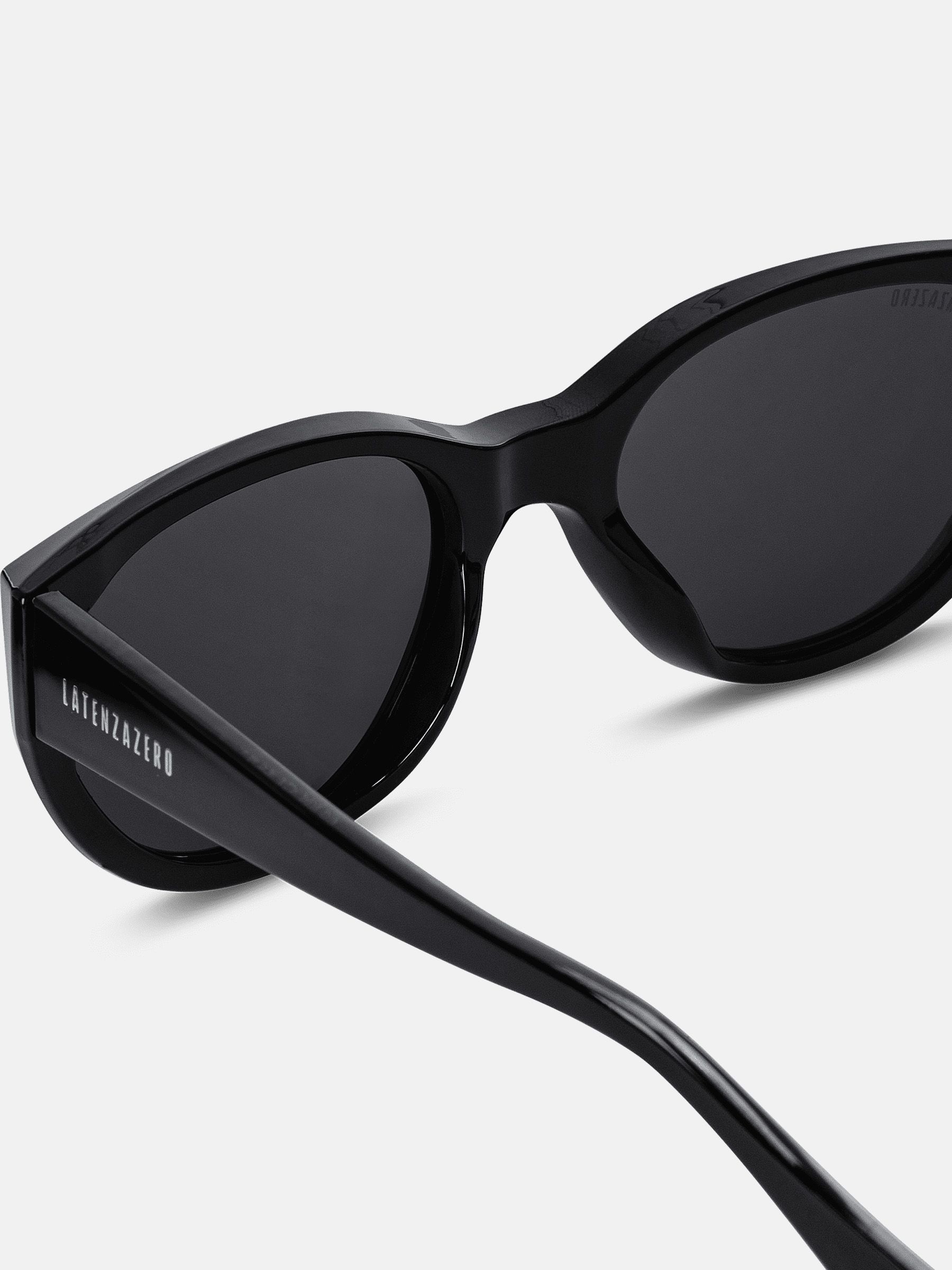 Primo piano degli occhiali da sole neri. Logo Latenzazero visibile.