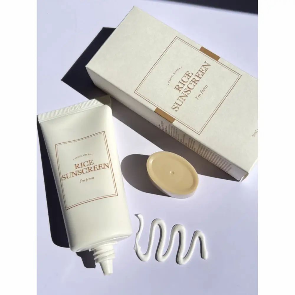 Tubo crema, scatola e coperchio. Scritta « Rice Sunscreen » e « I'm from ». Filo di crema.