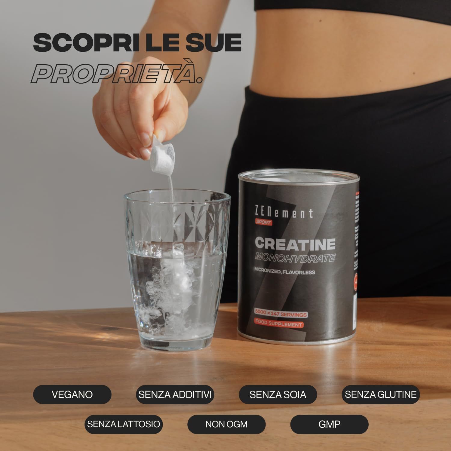 Persona versa polvere in un bicchiere d'acqua. Barattolo Zenement Creatina Monoidrato. Testo: Vegano, senza additivi, senza soia, senza glutine, senza lattosio, non OGM, GMP.
