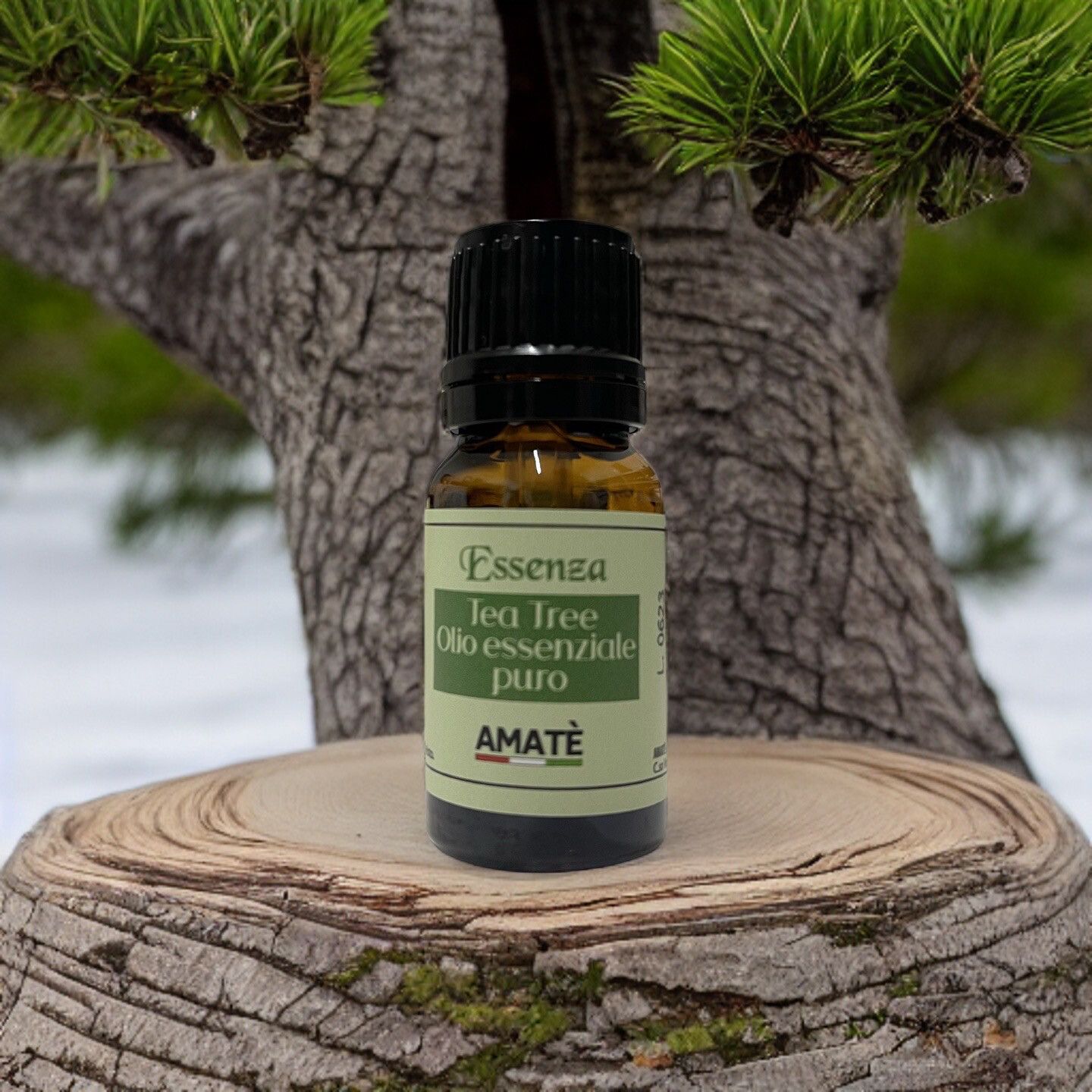 Flacone marrone con tappo nero. Etichetta: Essenza Tea Tree Olio essenziale puro. AMATÈ. Su ceppo, sfondo: albero.