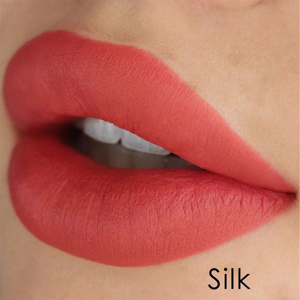 Labbra con rossetto corallo. Testo Silk.