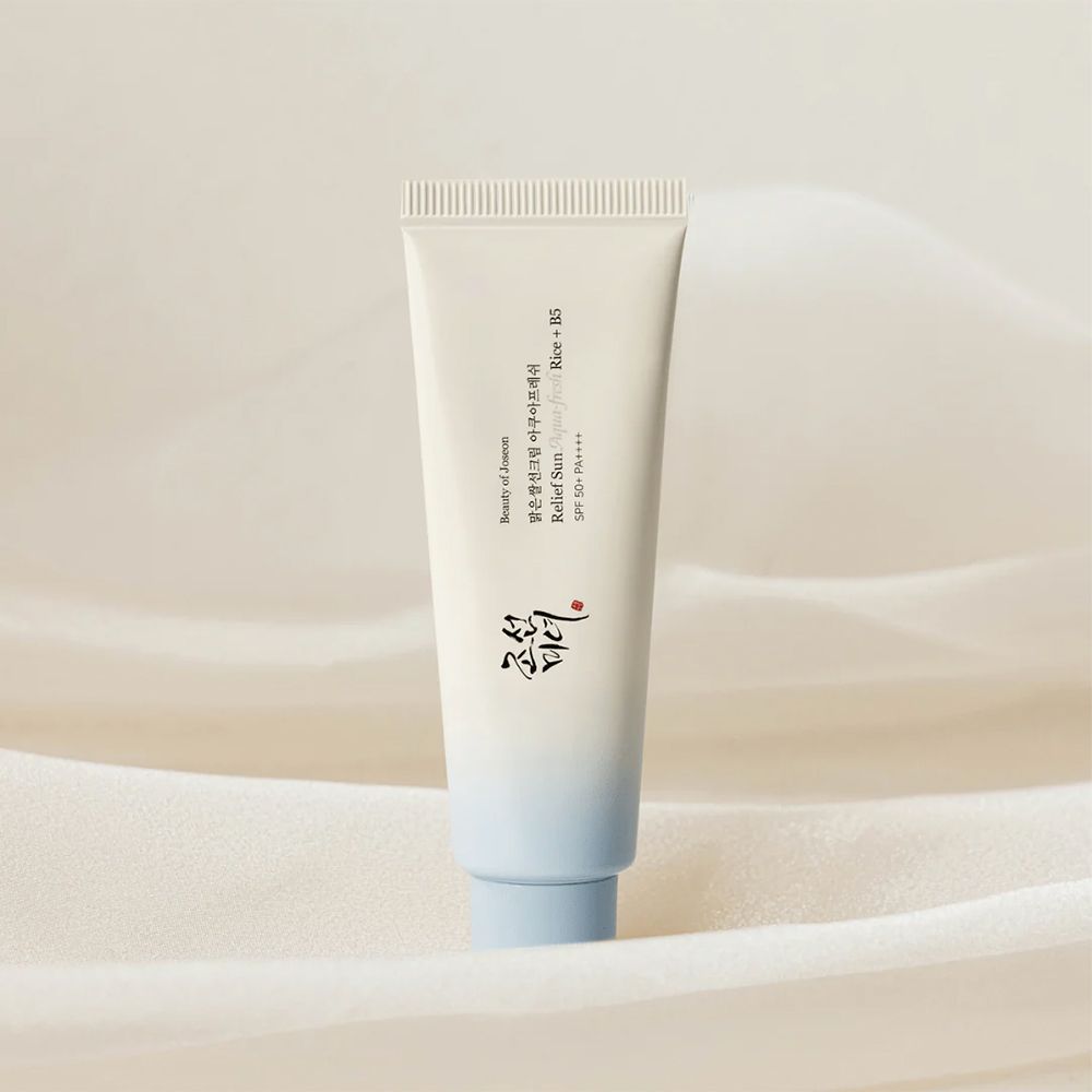 Tubo bianco con tappo blu, protezione solare con riso e B5.