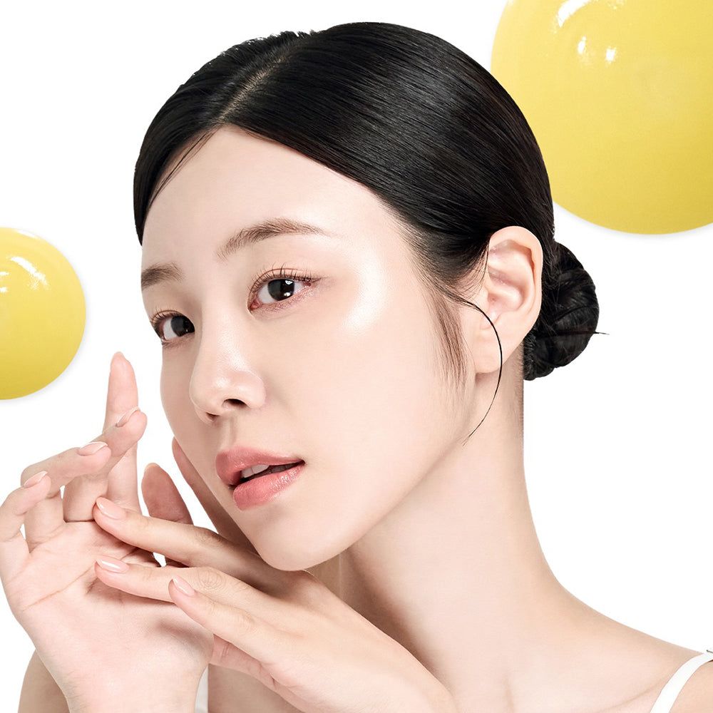 Ritratto di una donna con la pelle liscia. Gocce gialle sullo sfondo. Donna con i capelli raccolti.