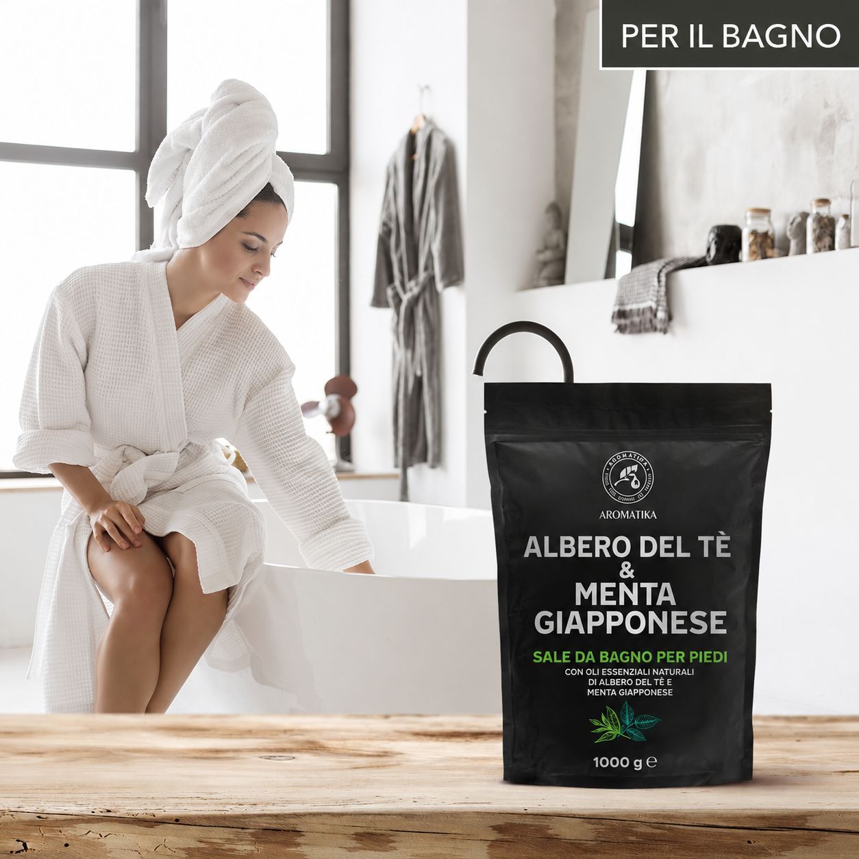 Donna in accappatoio. Confezione nera. Testo: 'Per il bagno'. Bagno e accessori da bagno sullo sfondo.
