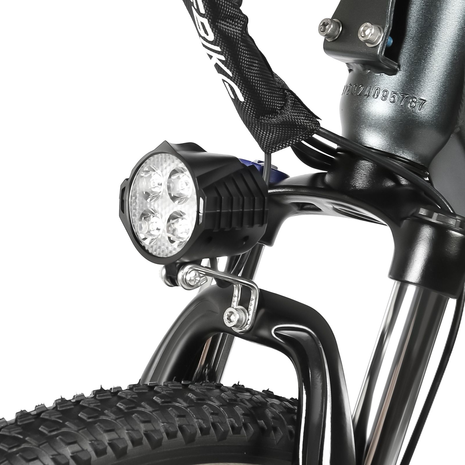 Primo piano del faro anteriore di una e-bike. Alloggiamento nero, luci a LED, pneumatico nero.