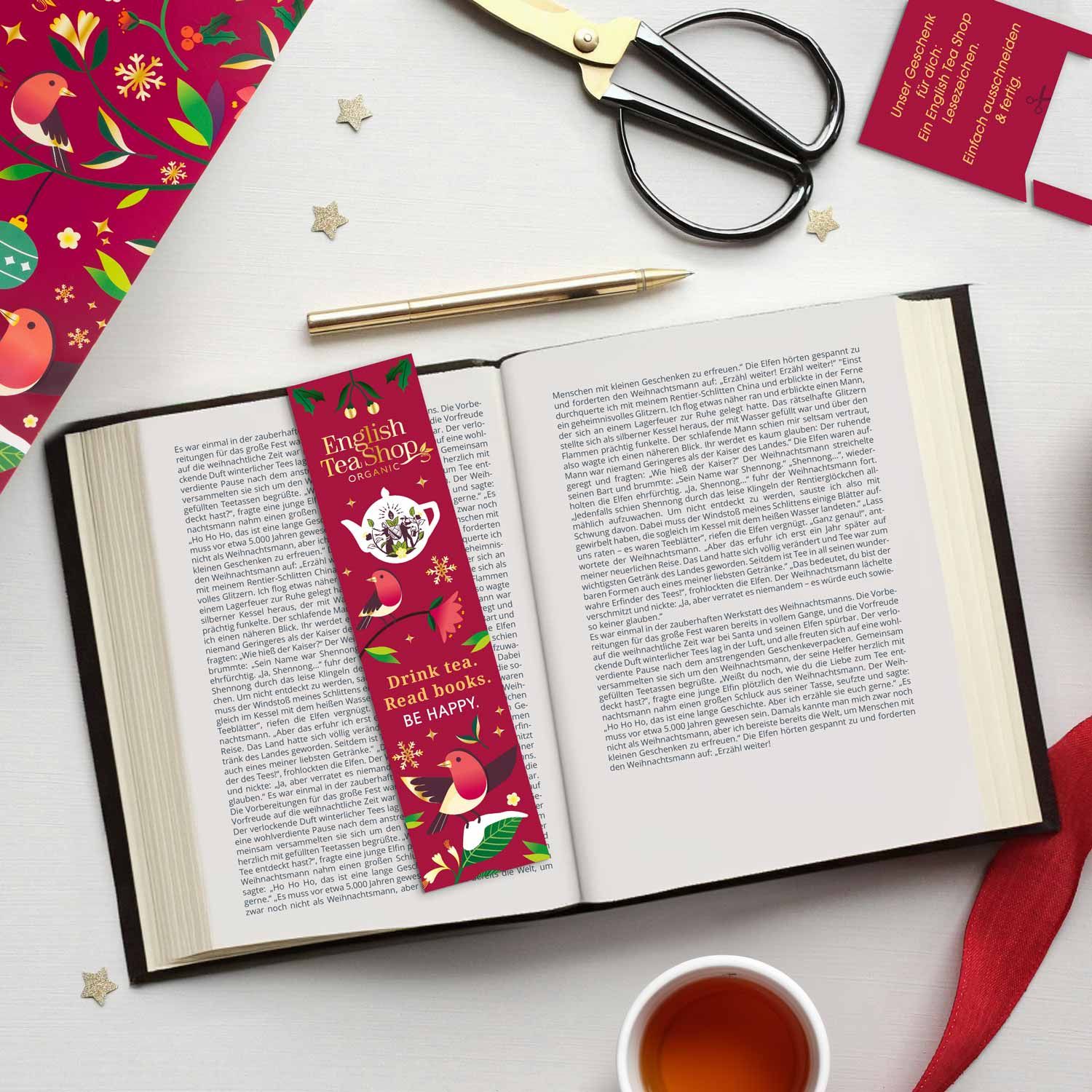 Libro aperto con segnalibro. Segnalibro: English Tea Shop, con uccelli e testo. Tazza di tè.