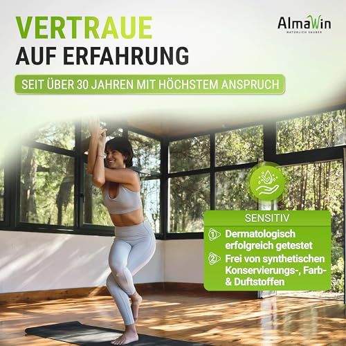 Donna in posa yoga in una stanza con grandi finestre, accanto a un campo verde con testo.