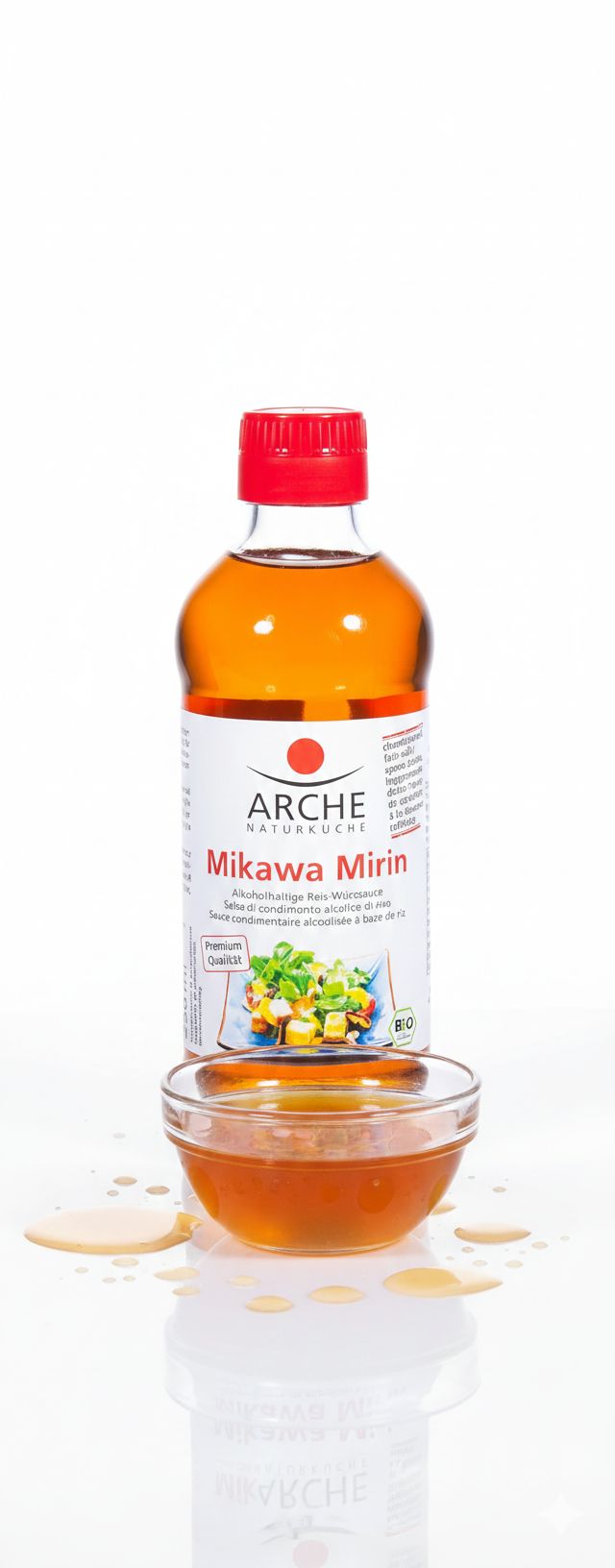 Salsa di condimento al riso Arche Mikawa Mirin in bottiglia di vetro con tappo rosso, accanto a una ciotolina con salsa.
