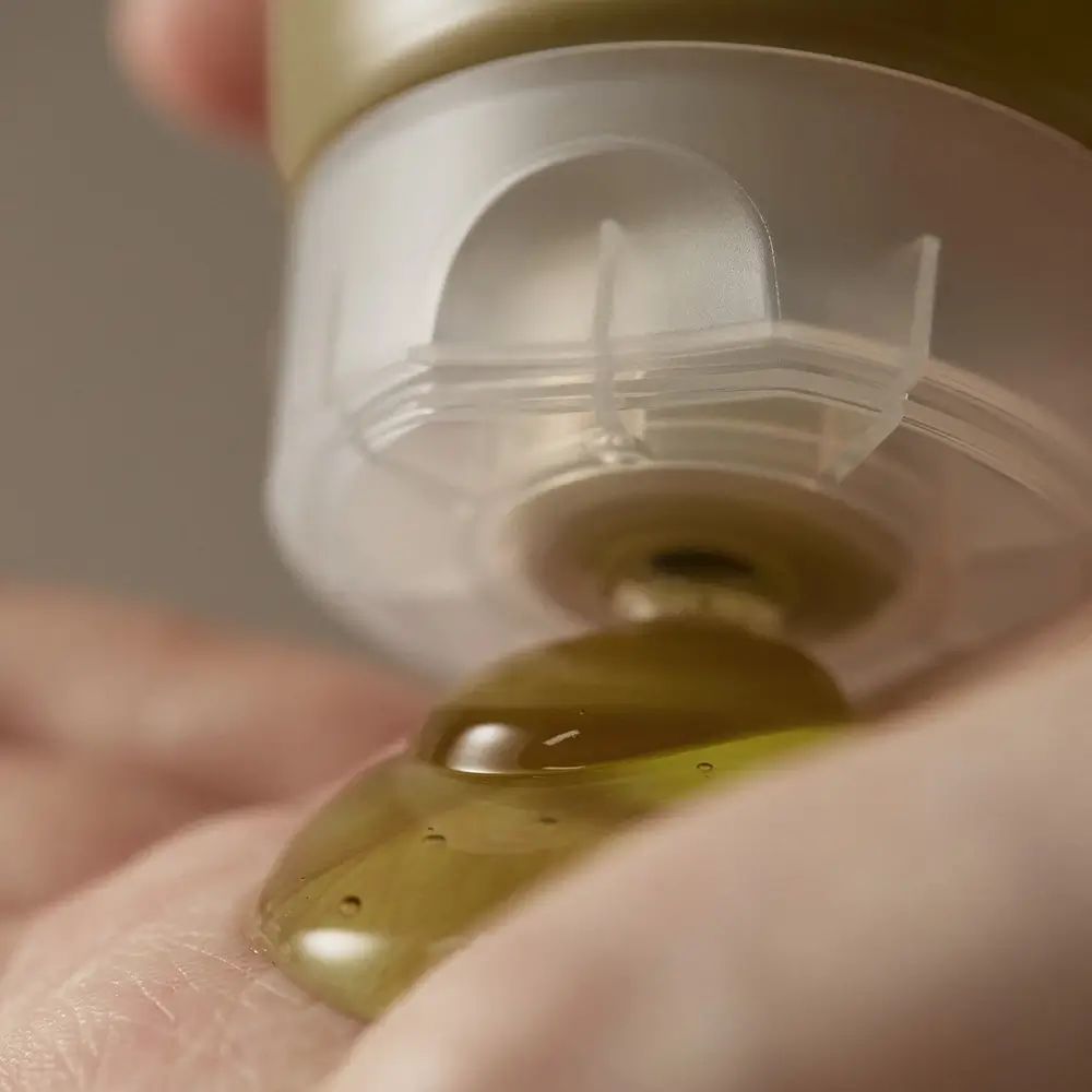 Primo piano: gel versato da un tubo nella mano. Gel trasparente.