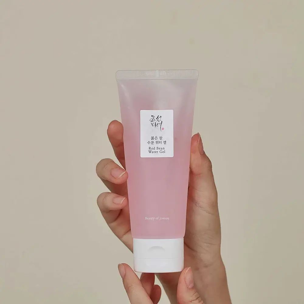 Mani che tengono un tubetto di gel rosa. Nome del prodotto e marchio in coreano e inglese.