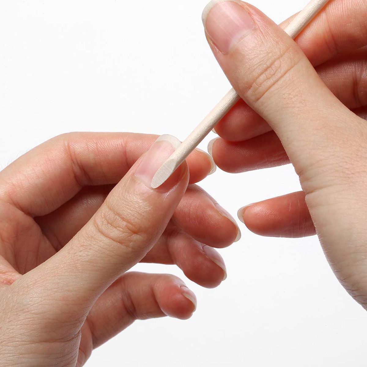 Bastoncino per manicure in uso. Un bastoncino viene utilizzato su un dito. Colore legno, punta arrotondata.