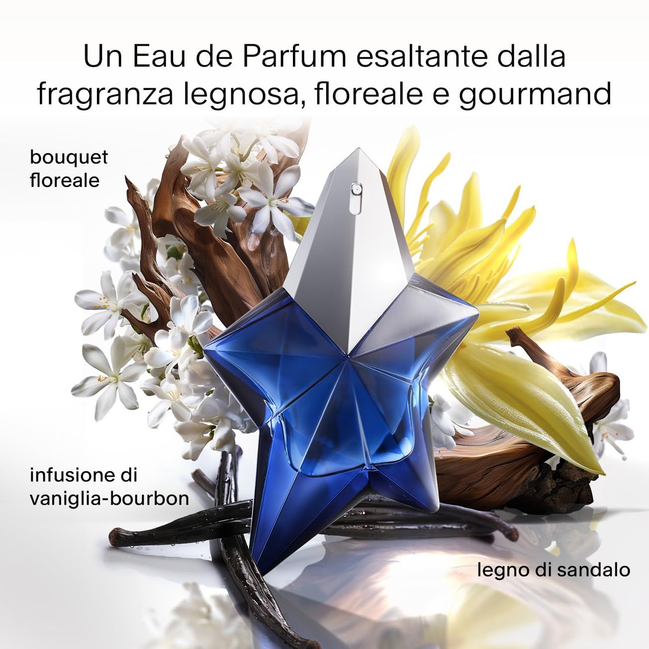 Flacone a stella blu con tappo argentato, circondato da fiori, legno e baccelli di vaniglia.