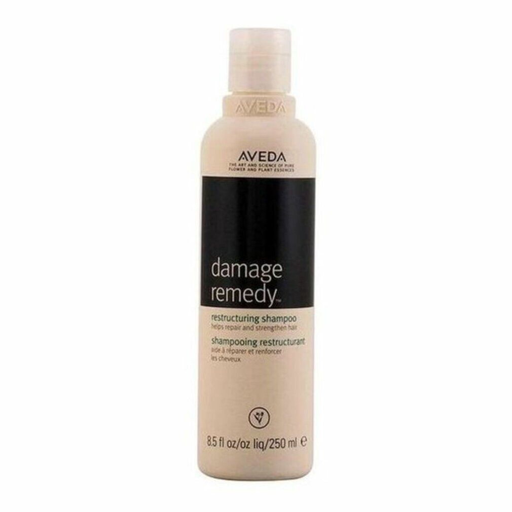 Flacone di shampoo beige con etichetta nera. Scritta: Aveda, Damage Remedy, Restructuring Shampoo. 250 ml.