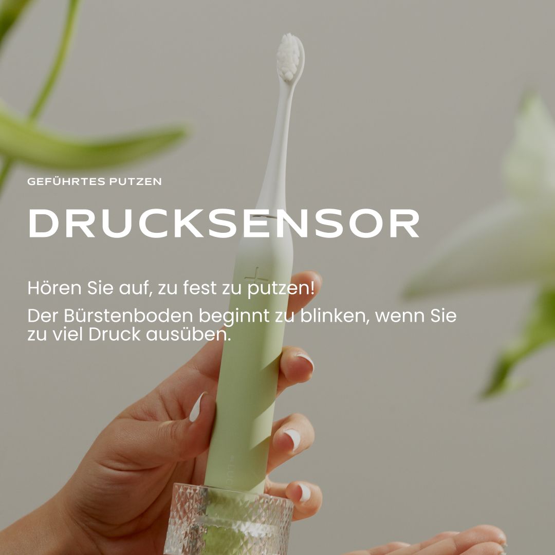 Mano che tiene uno spazzolino elettrico sonico verde Be Lucent Prism con sensore di pressione.