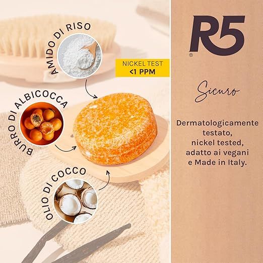 Sapone rotondo arancione su legno. Testo: 'Nickel Test <1 PPM'. Ingredienti: amido di riso, albicocca, olio di cocco. Logo R5.