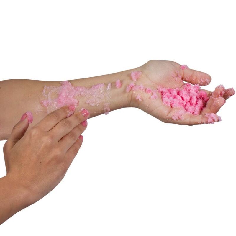 Sali da bagno rosa su braccio e mano. Grana grossa. Contatto con la pelle.