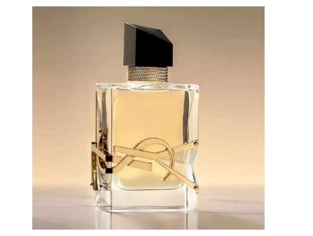 Flacone di profumo con logo dorato e tappo nero. Forma rettangolare, dettagli dorati.