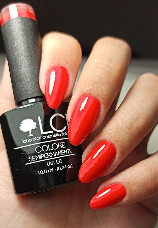 Unghie rosse e flacone di smalto. Scritta: LCI, Colore Semipermanente, UVLED.