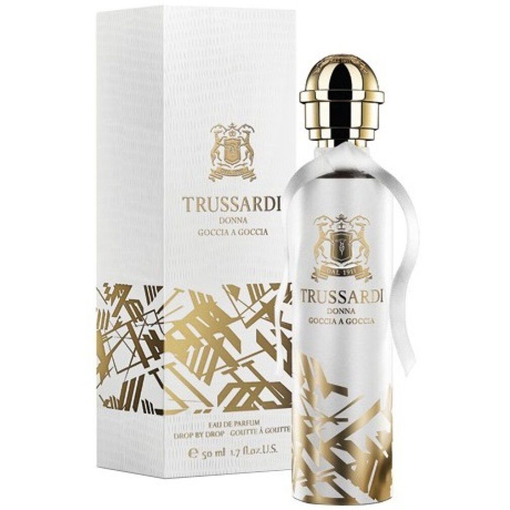 Flacone di profumo e confezione. Marchio: Trussardi Donna Goccia a Goccia. Dettagli dorati. Flacone con tappo dorato e nastro bianco.