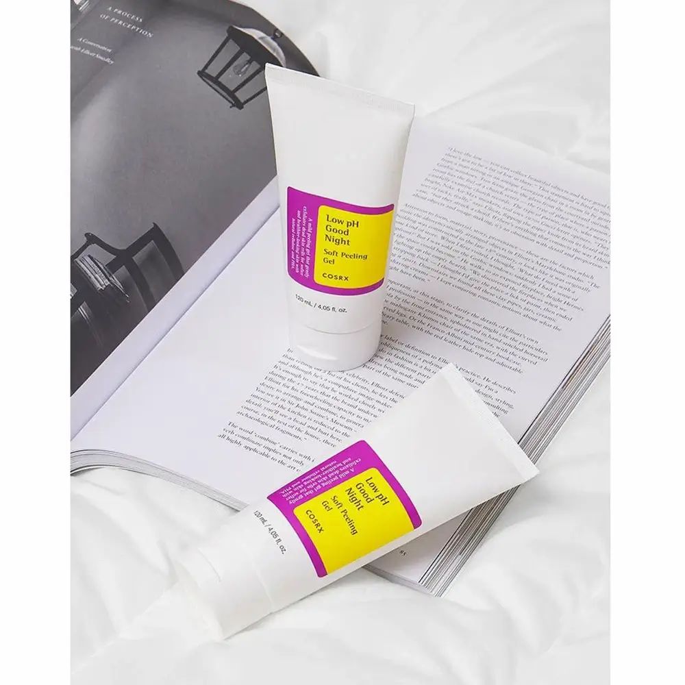 Due tubi su un libro aperto. Scritta: Low pH Good Night Soft Peeling Gel. Marchio COSRX. Sfondo bianco.