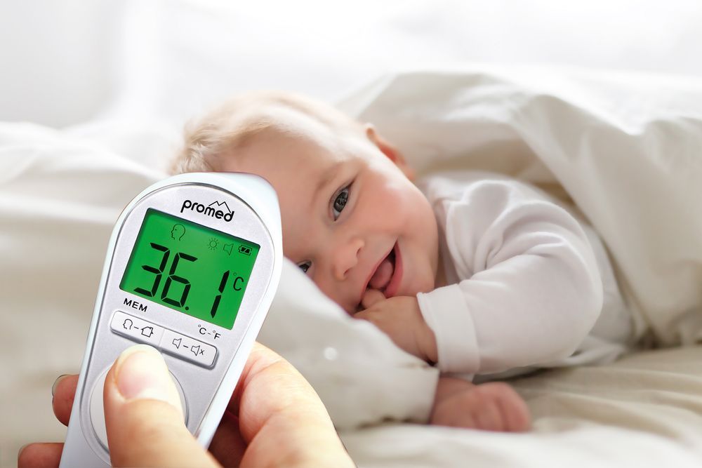 Termometro misura la temperatura del bambino. Display: 36,1°C. In alto: "promed".