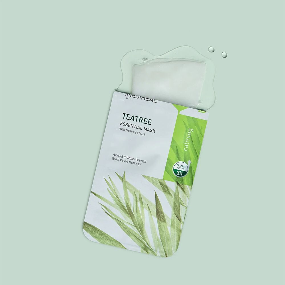 Confezione aperta con maschera. Scritta: Tea Tree Essential Mask. Striscia verde con testo. Acqua e gocce.
