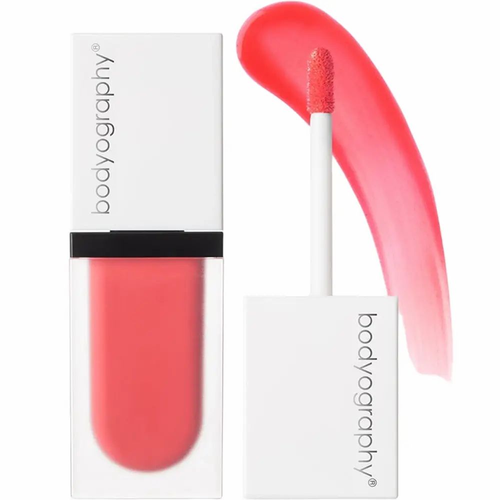 Flacone di rossetto liquido e applicatore. Marchio BODYOGRAPHY. Coperchio bianco, custodia trasparente. Colore corallo.