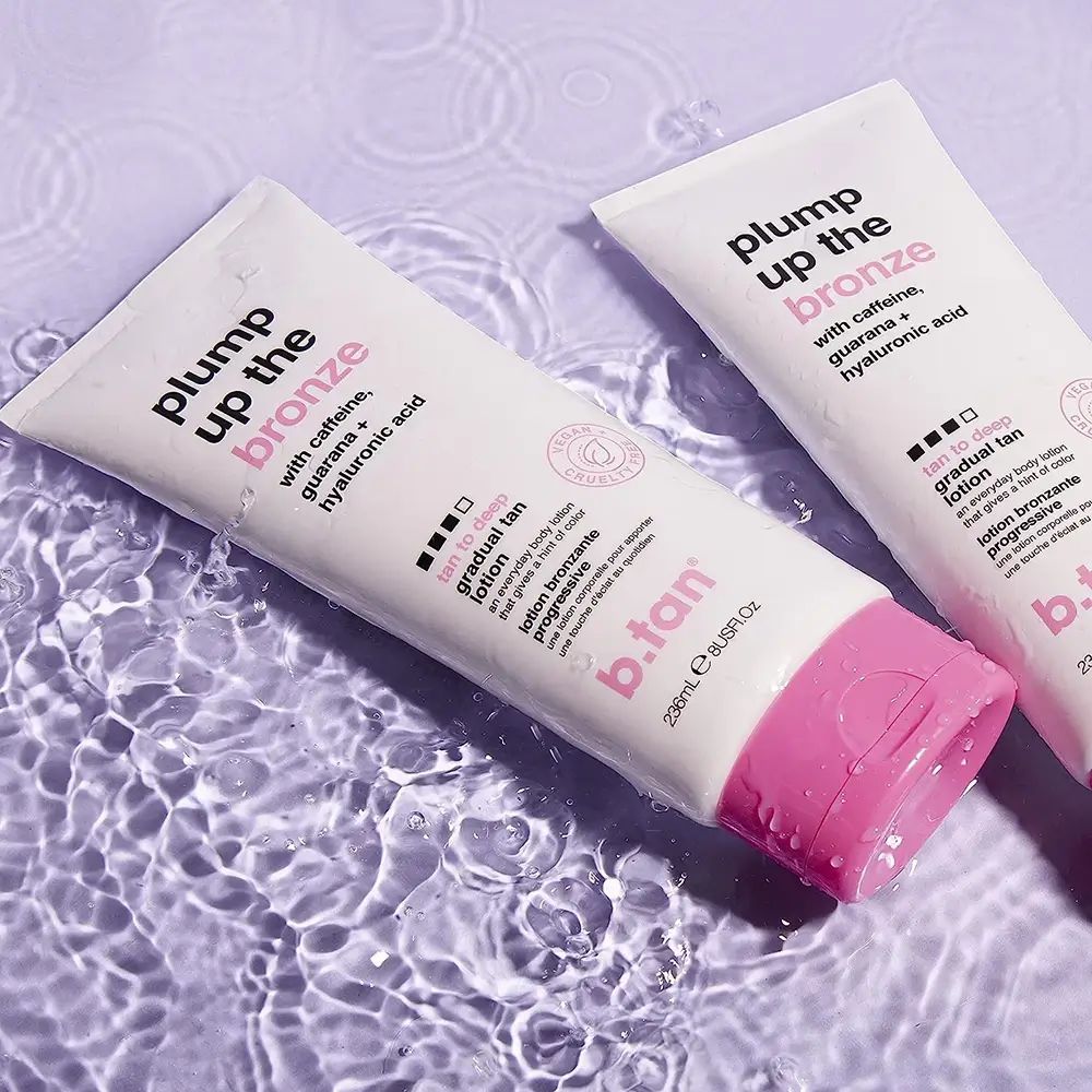 Due tubi bianchi con dettagli rosa nell'acqua. Testo: Plump Up the Bronze, tan to deep. Logo B.tan. Ingredienti: caffeina, guaranà, acido ialuronico.
