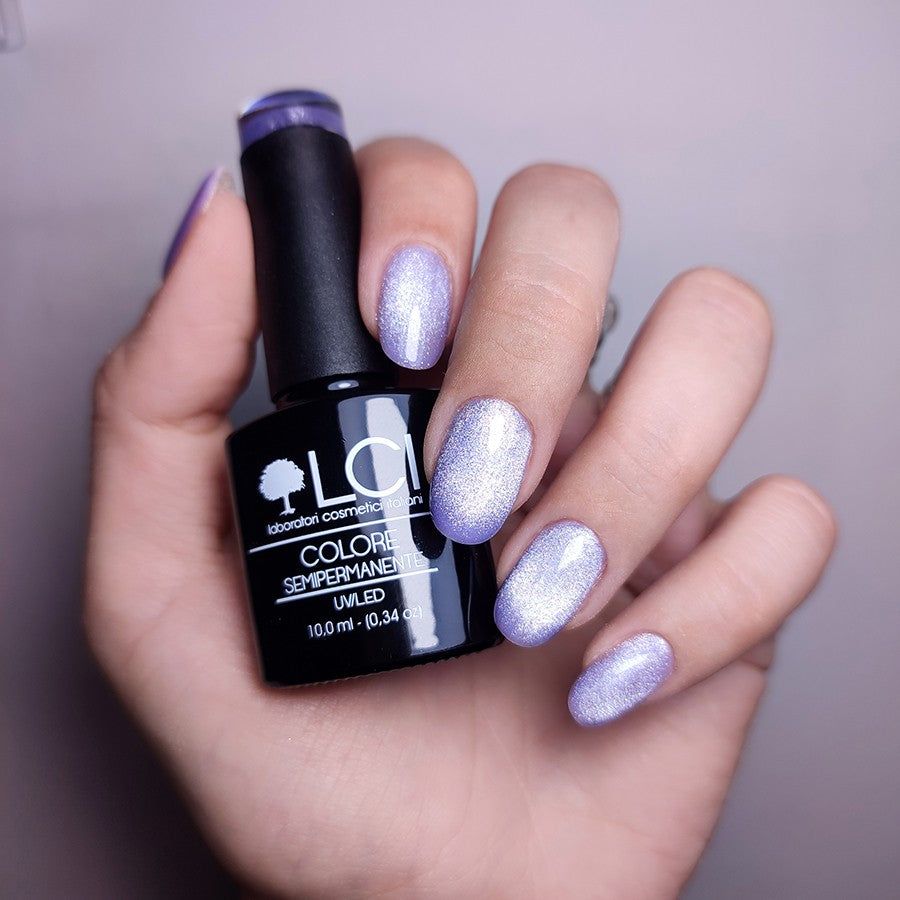 Mano con unghie smaltate e flacone di smalto. Scritta: LCI, Colore Semipermanente, UVLED. Tonalità: CAT 11, Effetto Cat Eye.