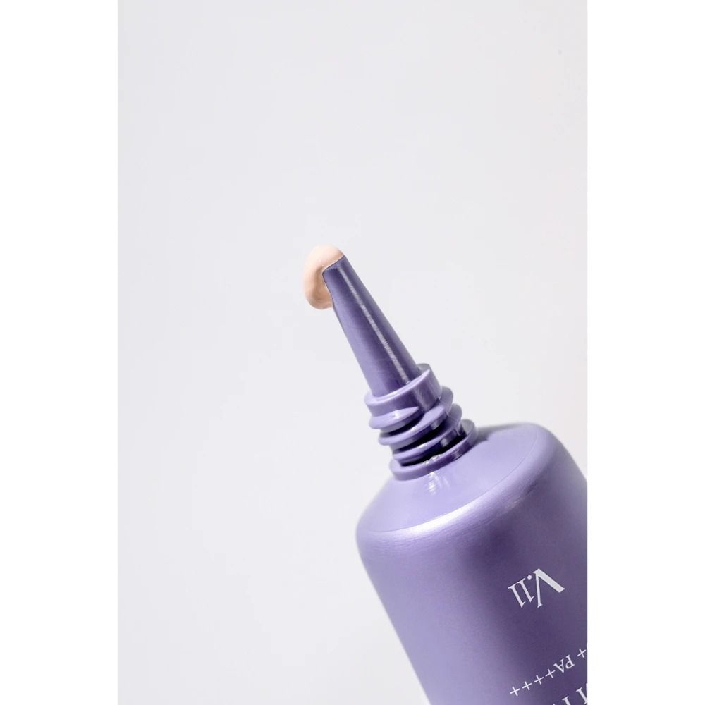 Primo piano di un tubo di BB Cream. La crema esce dall'apertura. Tubo lilla con tappo argentato.