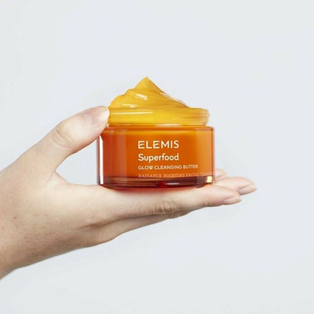 Vasetto in vetro arancione con Elemis Superfood Glow Cleansing Butter. Burro giallo applicato sul bordo.