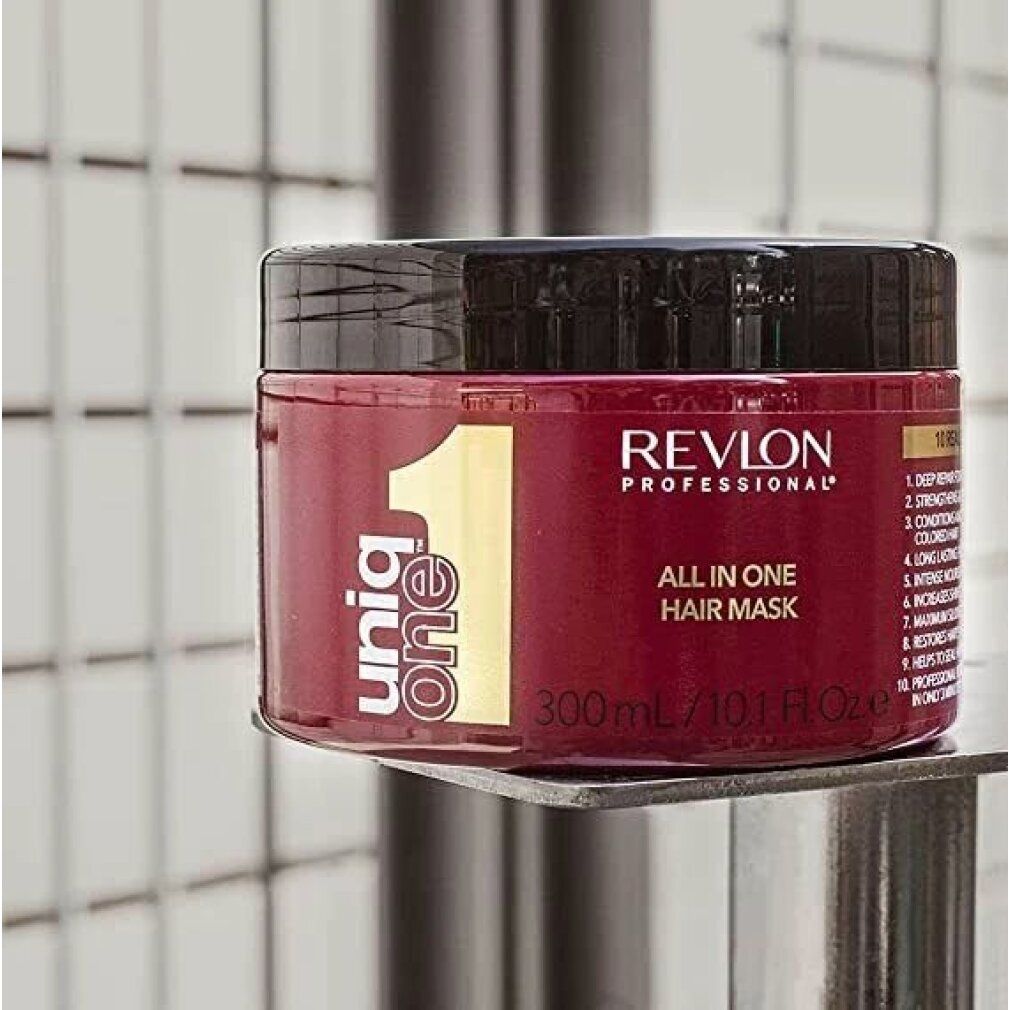Barattolo rosso con coperchio nero. Scritta: Revlon Professional, UniqOne, All in One Hair Mask. 300ml/10.1 Fl.oz.e. Su mensola.
