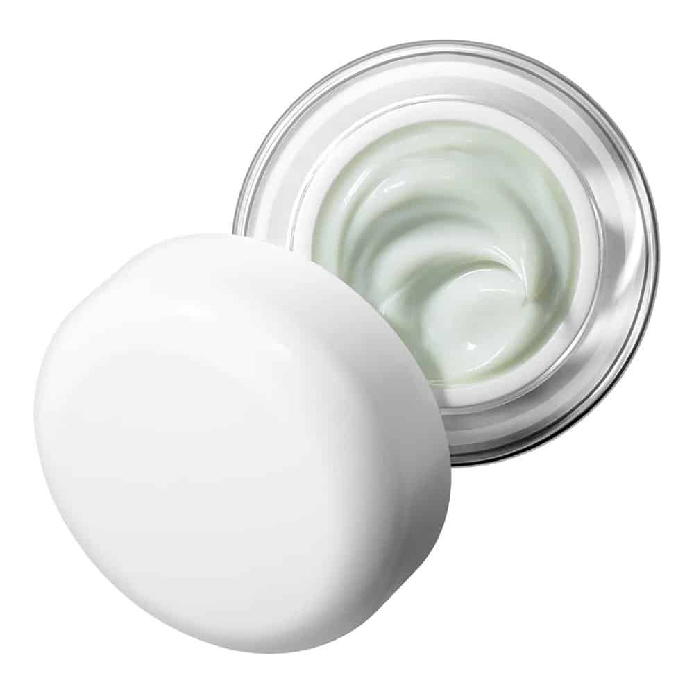 Vasetto aperto con crema verdastra. Coperchio bianco accanto.