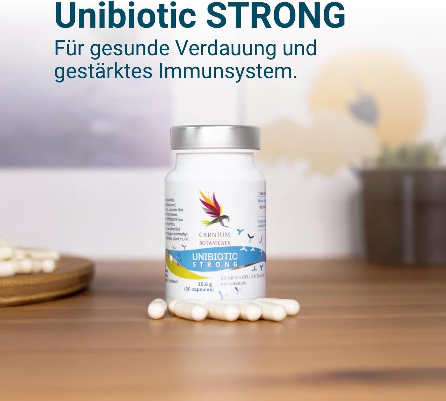 Flacone con capsule su superficie in legno. Scritta: Unibiotic STRONG, 20 miliardi di CFU/15 ceppi. Marchio: CARNIUM BOTANICALS. Capsule accanto.