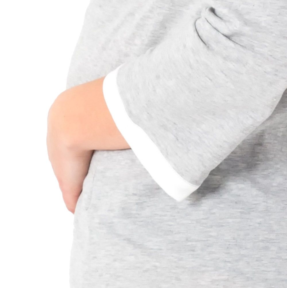 Primo piano della camicia premaman grigio mélange a maniche lunghe. Bordo bianco sulla manica.