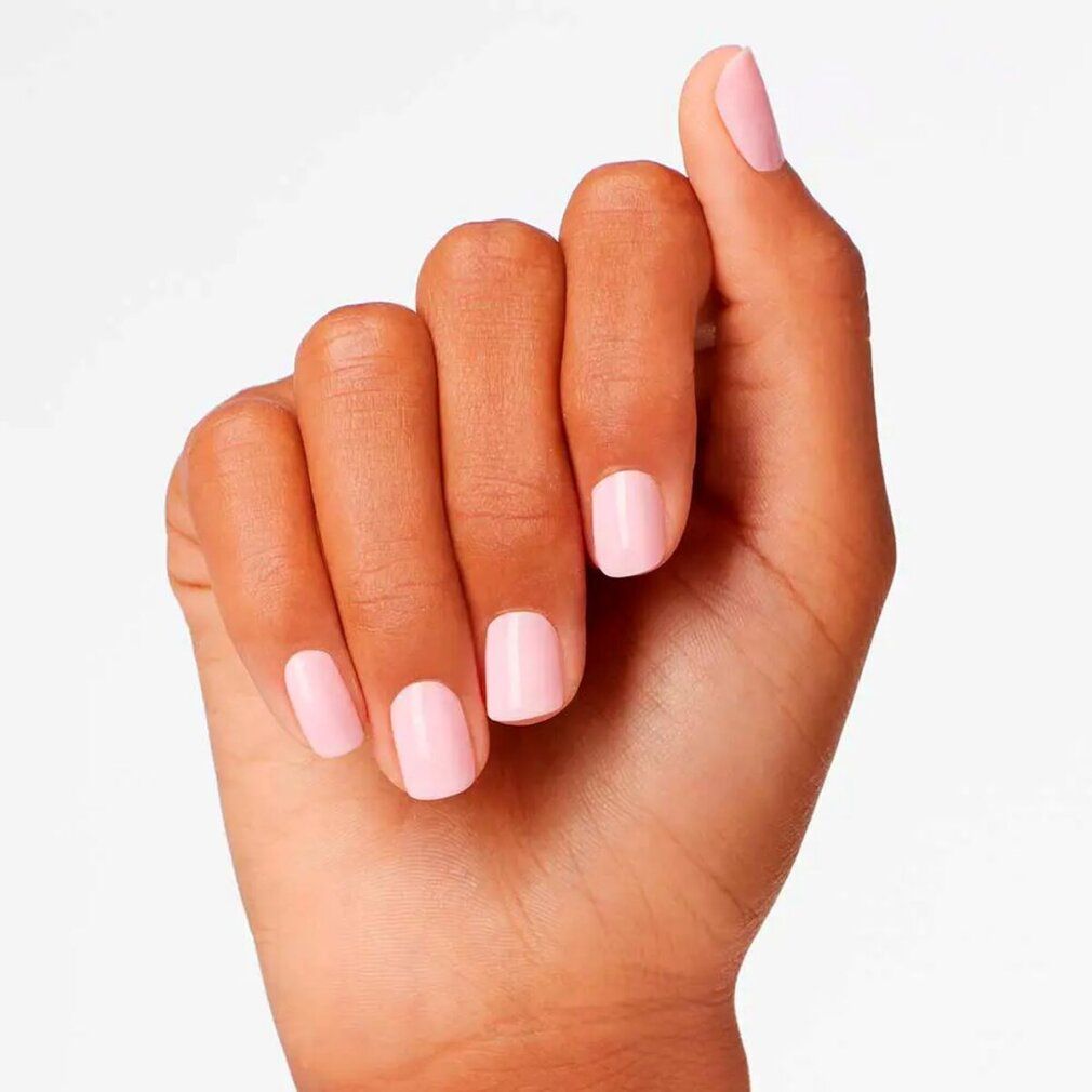 Mano con unghie laccate di rosa. Tutte le unghie sono laccate in modo uniforme.