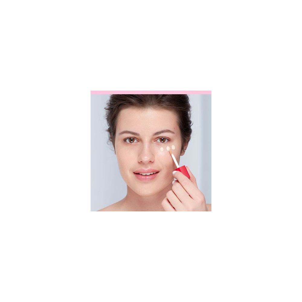Donna che tiene un applicatore per applicare il prodotto sul contorno occhi.
