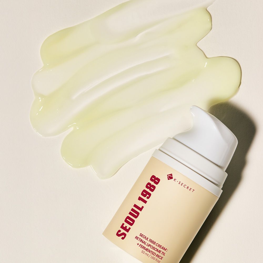 Crema viso K-Secret Seoul 1988 su una superficie con un flacone dispenser accanto.