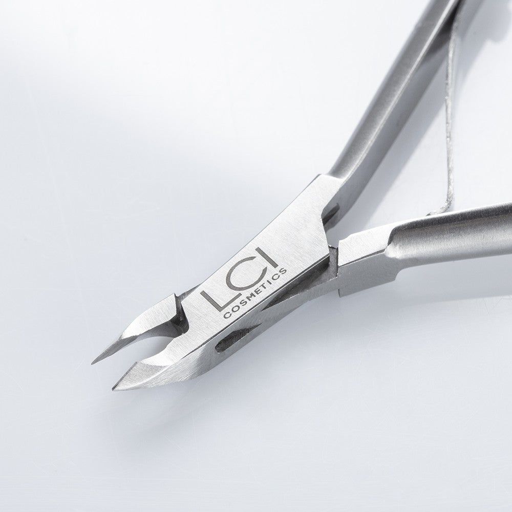 Primo piano della tronchesina. Logo LCI Cosmetics. Metallo, taglio affilato, vista dettagliata.