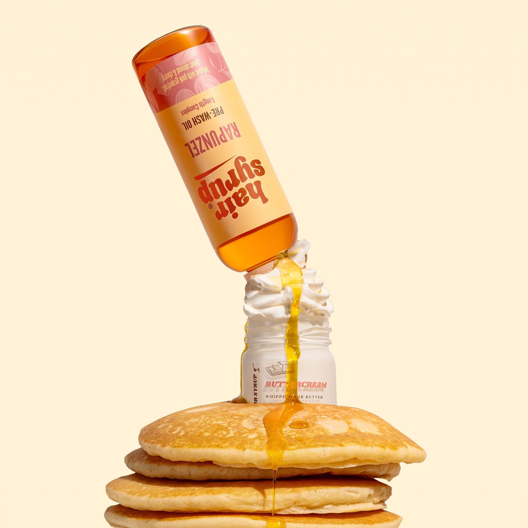 Bottiglia Hair Syrup Rapunzel, Pre-Wash Oil, versata su una pila di pancake. Liquido giallo che cola.