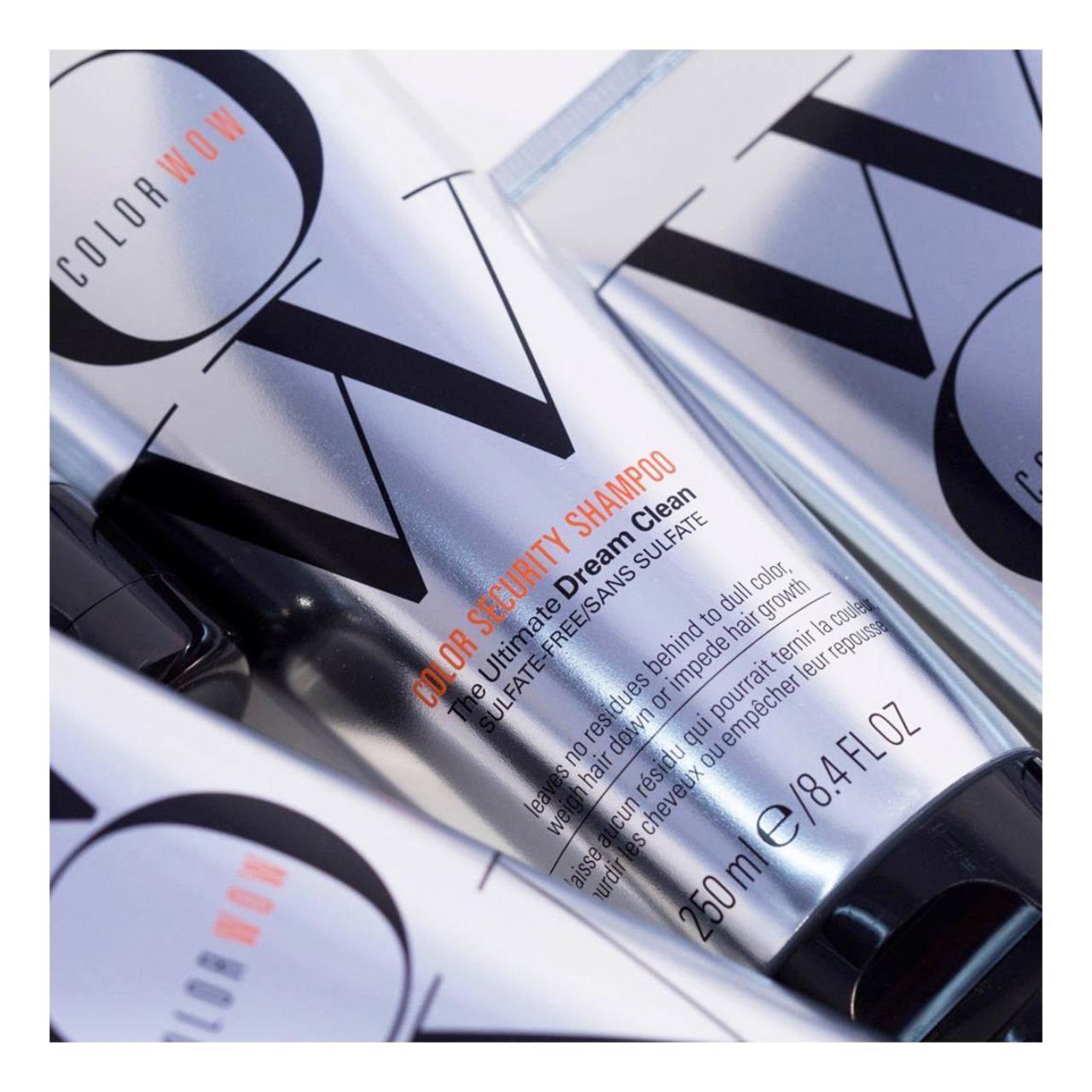 Diversi tubi argentati con tappo nero. Scritta: WOW, Color Security Shampoo. Testo: 250 ml/8.4 fl oz.