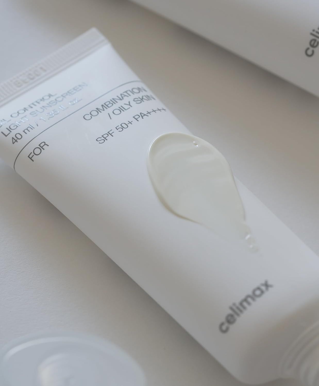 Tubo bianco di crema solare con una macchia di crema accanto.