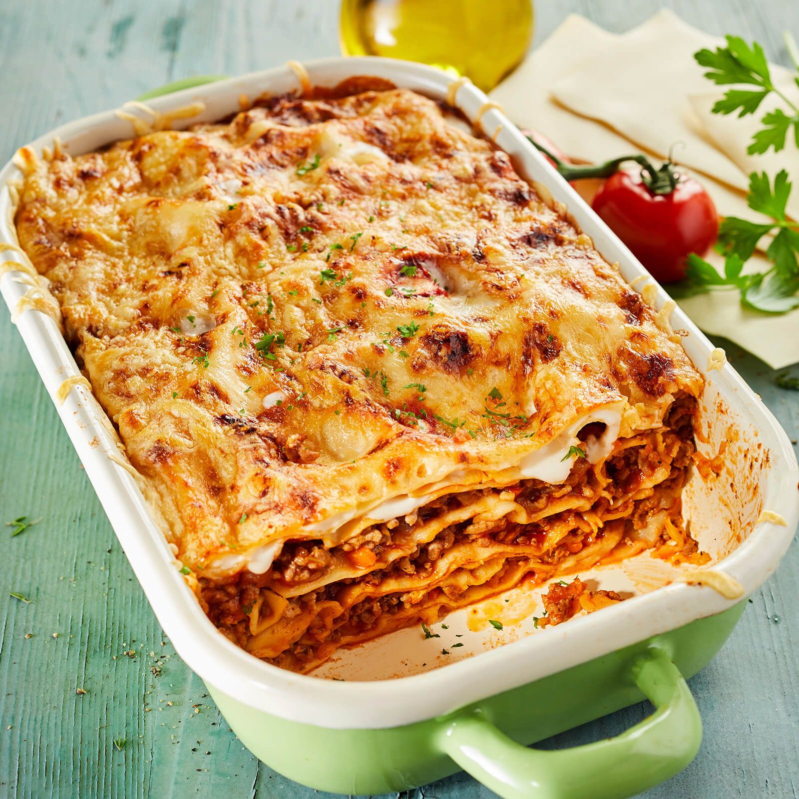 Grande pirofila con lasagne. Diversi strati di pasta, carne e formaggio. Gratinate.