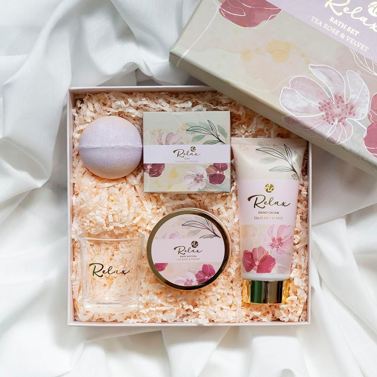 Confezione regalo con prodotti per bagno e cura della persona. Contiene crema mani, bicchiere, bomba da bagno, sapone e crema. Accenti rosa e oro.