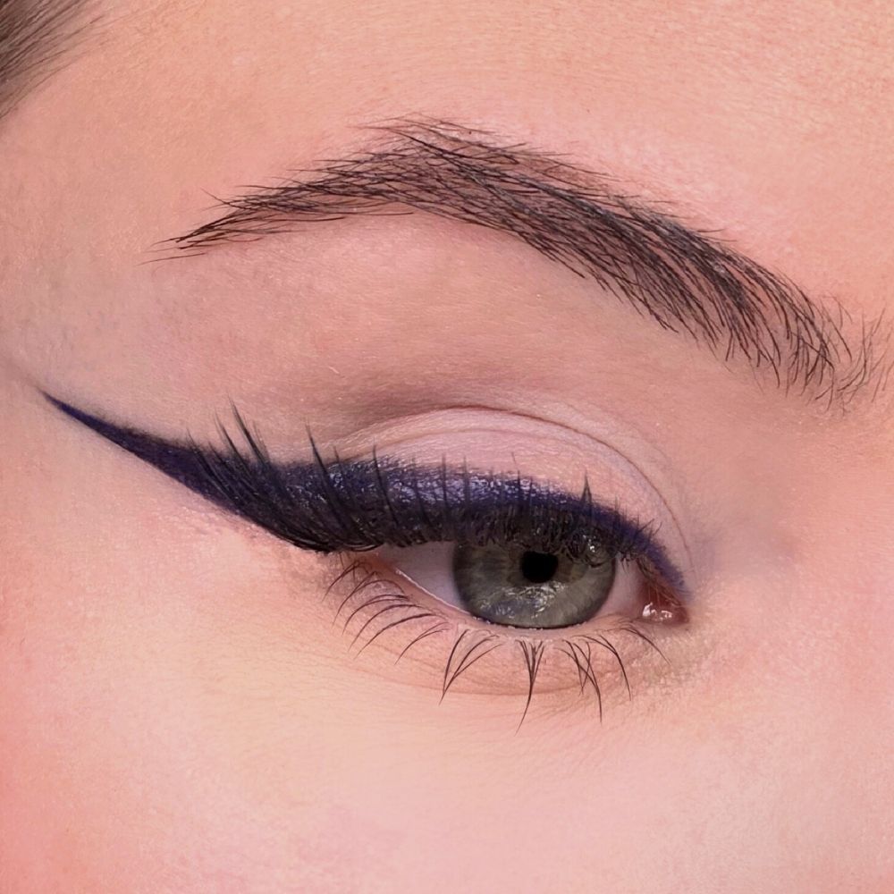 Occhio con eyeliner blu. Palpebra superiore evidenziata. Sopracciglio visibile. Tono della pelle chiaro.