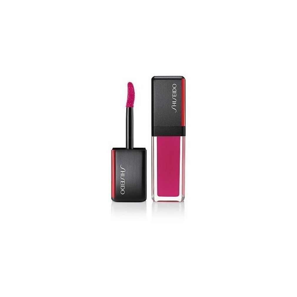 Rossetto con tappo nero e accento rosso. L'applicatore è estratto. Logo Shiseido sul tappo.