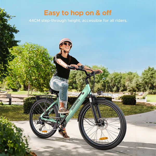 Donna in sella a e-bike verde chiaro. Testo: altezza di accesso 44cm. Facile da salire e scendere.