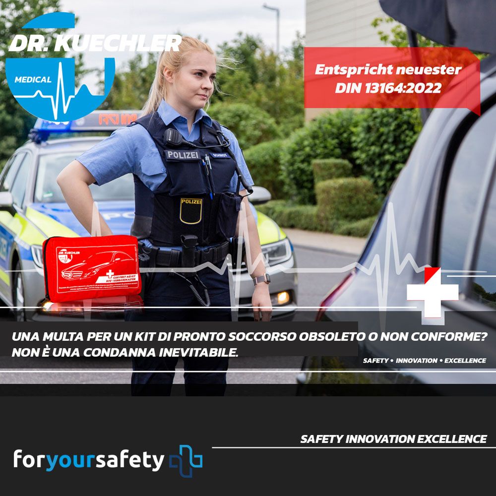 Poliziotta accanto all'auto. Borsa rossa per pronto soccorso. Marchio: Dr. Kuechler Medical. Testo: Conforme alla più recente DIN 13164-2022.