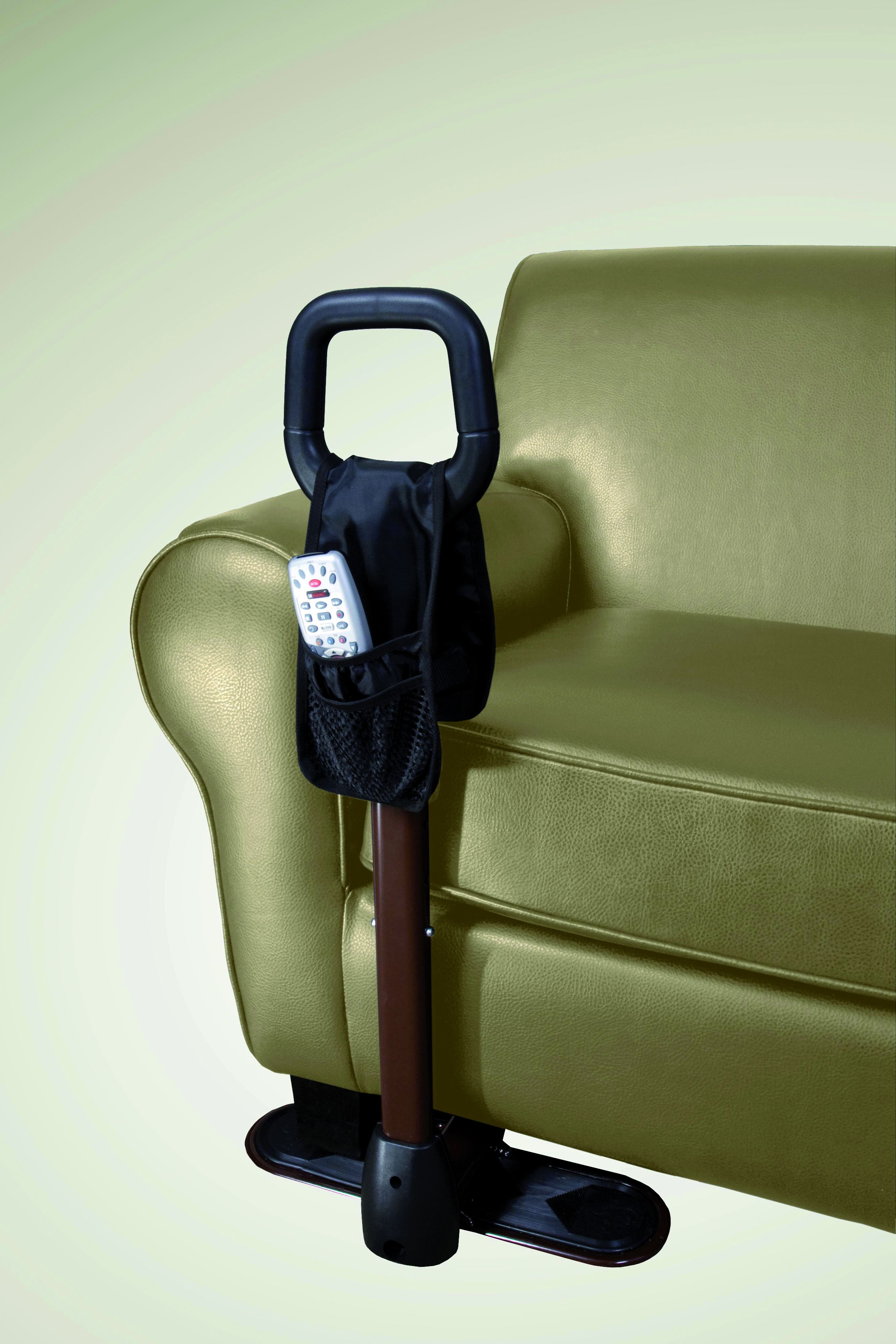 Ausilio per sollevamento accanto a poltrona verde. Maniglia nera, asta marrone, base nera. Con tasca e telecomando.